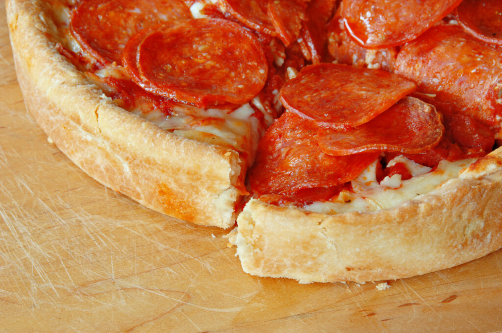 Sliced deep dish pepperoni pizza.